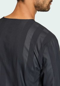 Black long-sleeve shirt with smooth texture featuring horizontal stripes in varying shades of black. Crew neckline and relaxed fit design.