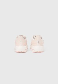 Zapatillas ligeras rosas con parte superior texturizada, talones redondeados, cuellos acolchados y una suela blanca gruesa. Detalles sutiles en un suave tono rosa.