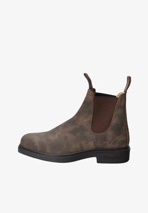 Bottines en cuir marron avec panneaux élastiques sur les côtés, finition texturée, bout arrondi et semelle en caoutchouc noir. Boucles sur la tige pour un enfilage facile.