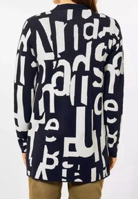 Cardigan navy con grandi lettere bianche a contrasto di dimensioni e font vari, texture a maglia e una vestibilità lunga e comoda.