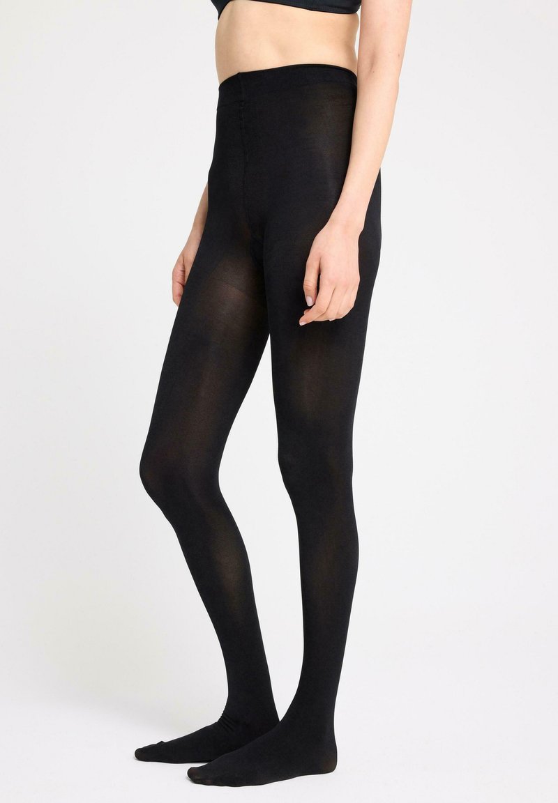 Sorte leggings lavet af tyndt, strækbart materiale, med en høj talje og sømløs design, der har en glat overflade og fodenede ender.