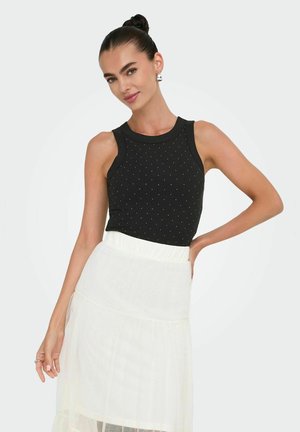Zwarte fitted tanktop met geribbelde textuur en zilveren studs details, gecombineerd met een gelaagde witte rok. Basis ronde halslijn, mouwloos ontwerp.