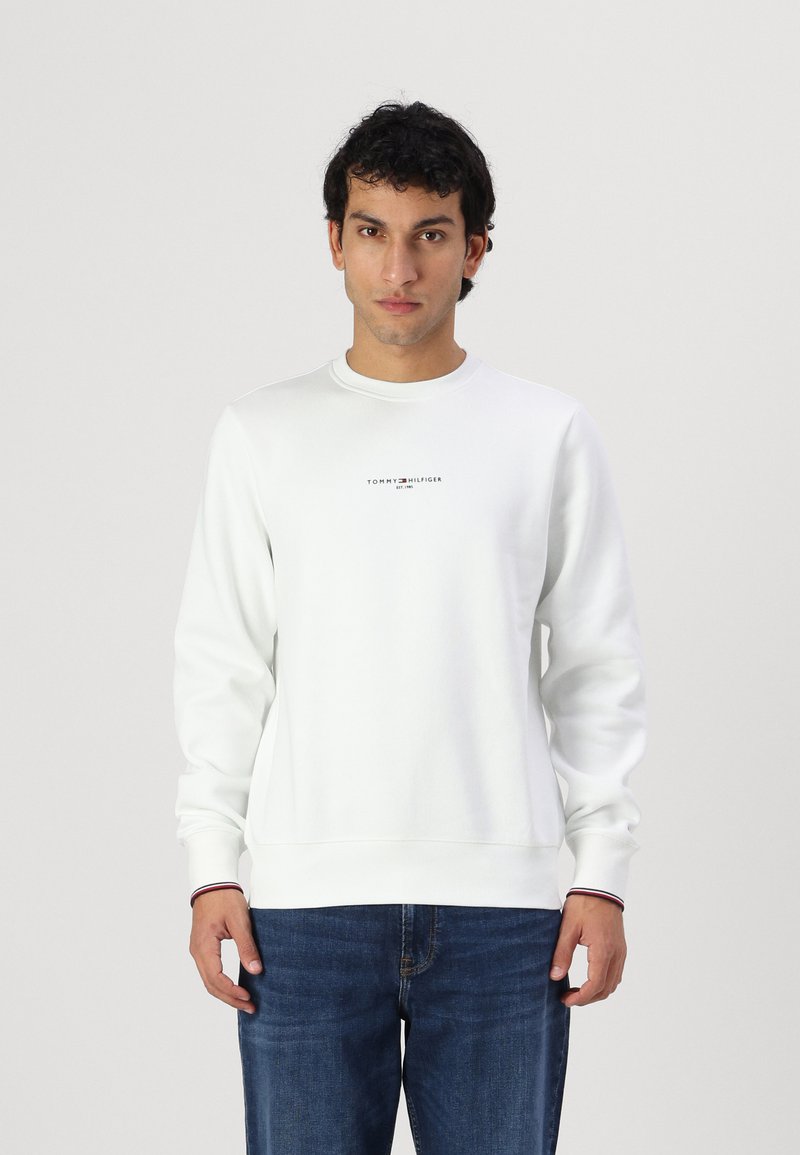Biely crewneck sveter z bavlnenej zmesi s rebrovanými manžetami, ktorý má malé logo na hrudi a zvýrazňujúce pruhy na leme.