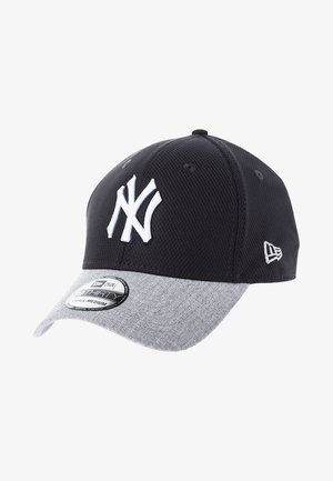 Zwart-grijze honkbalpet van de New York Yankees met wit geborduurd logo en maatsticker op de klep, schuin geplaatst om het zijlogo van New Era te tonen.