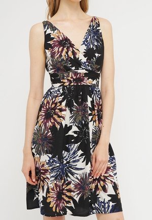 Robe sans manches avec col en V et taille ajustée, présentant un grand imprimé floral en noir, violet, doré et bleu sur fond blanc.