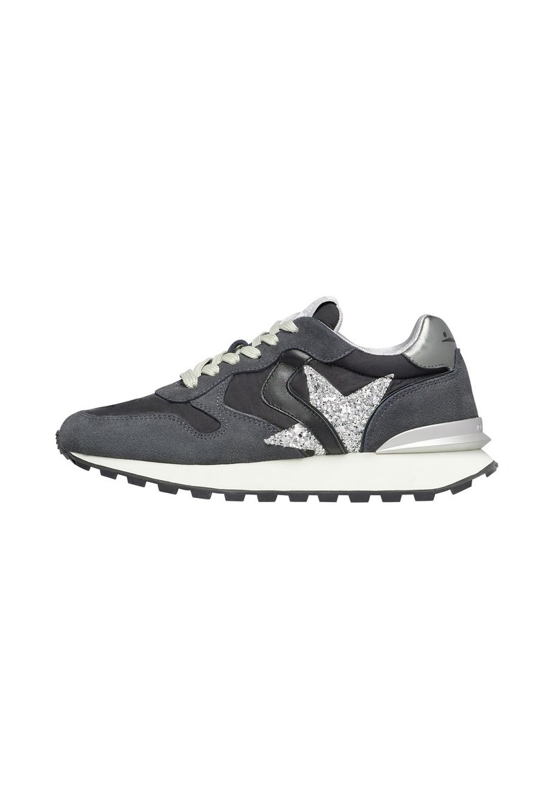 Sneaker in suede grigio con accenti di stelle argentate, dettagli in pelle nera, lacci grigio chiaro e una suola intermedia spessa bianca con suola nera.