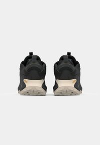 Czarne buty trekkingowe z teksturowaną cholewką, szarymi akcentami i beżową podeszwą Vibram. Posiadają pętlę ułatwiającą chwyt na pięcie.