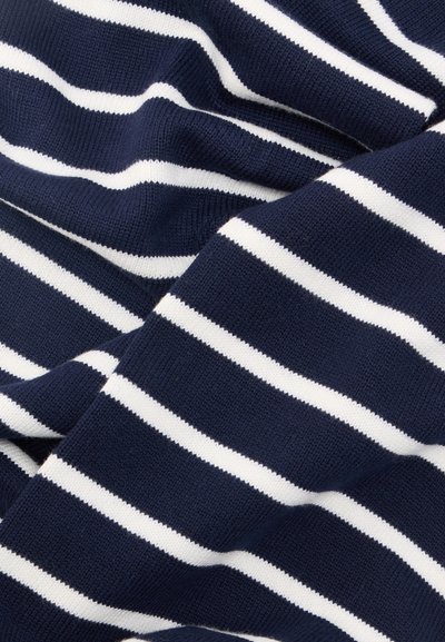 Ναυτικό μπλε πλεκτό ύφασμα με ομοιόμορφα κατανεμημένες οριζόντιες λευκές ρίγες, εμφανιζόμενο με απαλά πτυχώματα και λεπτομέρειες υφής.