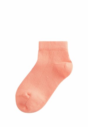 Katoenen enkelsok in zachte koraalkleur, met een geribbelde boord, een gladde textuur en een afgeronde teen. Minimalistisch ontwerp zonder patronen of accenten.