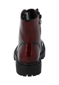 Burgundowa skórzana botka za kostkę o teksturowanym wykończeniu, z czarną gumową podeszwą, tylnym zamkiem błyskawicznym i uchwytem z etykietą "palad."