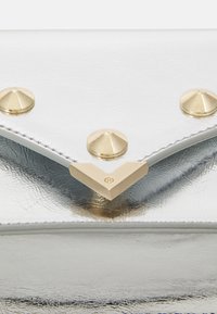 Silver metallic clutch bag with a textured finish. Features gold pyramid studs and a triangular gold hardware accent on the front.
