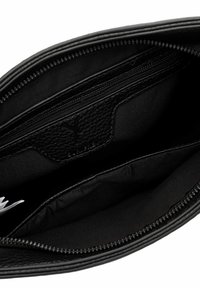 Melnas ādas somas iekšpuse, kurā redzams rāvējslēdzēja kabata, atvērta nodalījuma un teksturētas ādas detaļa.