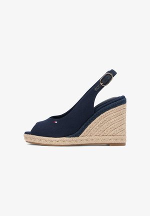 Marineblauwe sleehak sandaal met peep toe, verstelbare gespband en gevlochten jute plateauhak.