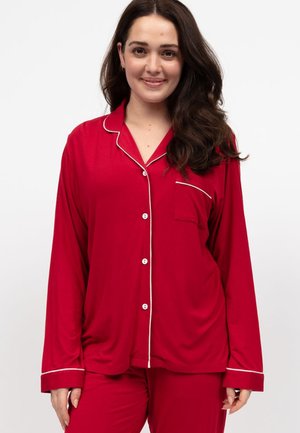 Conjunto de pijama rojo en tela suave con detalles en blanco. Cuenta con una camisa abotonada con un bolsillo en el pecho y manga larga, acompañada de pantalones a juego.