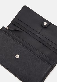 Czarny skórzany portfel o teksturowanym wykończeniu. Posiada zapięcie na zatrzask, kieszeń na zamek oraz sloty na karty w zorganizowanym układzie.