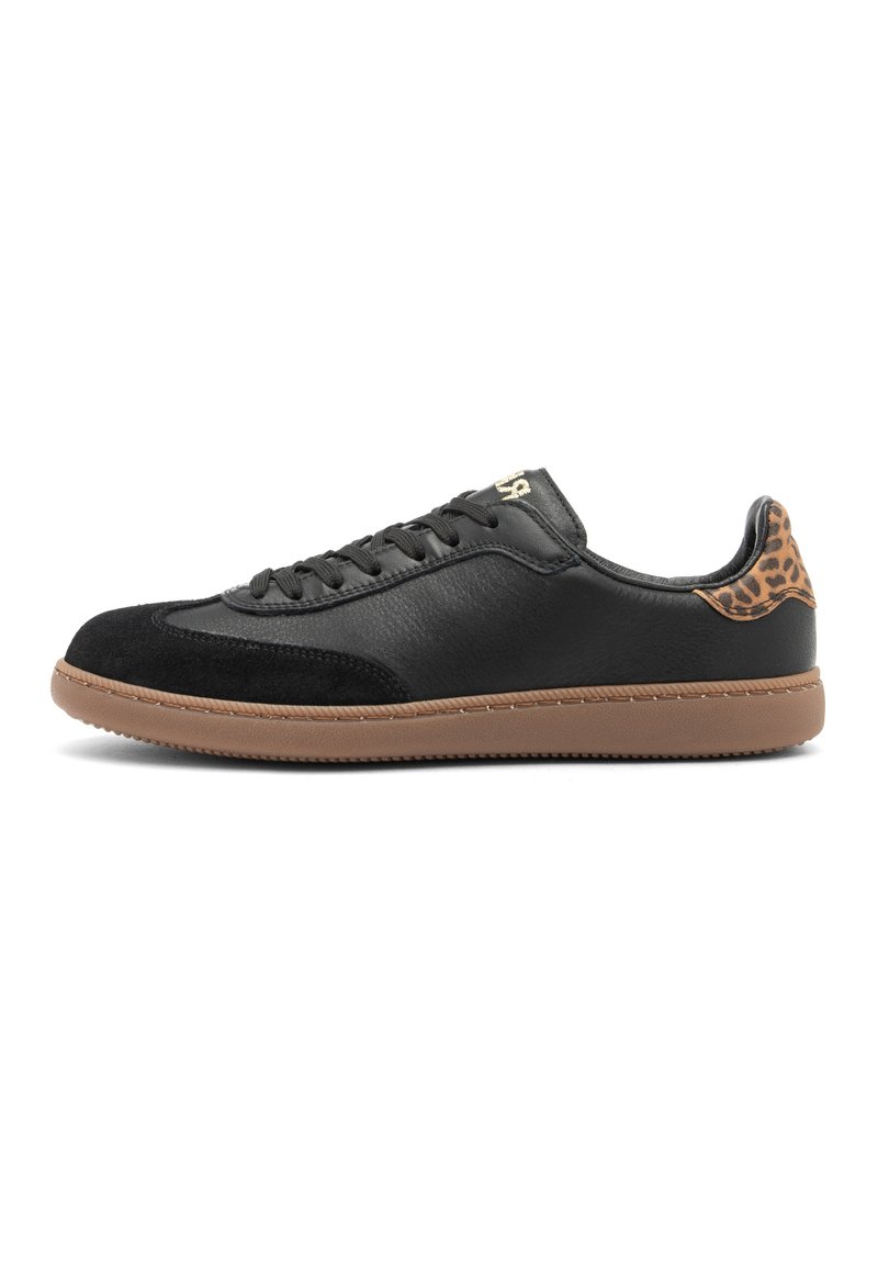Sneaker nera a bassa punta con suola marrone, punta in suede, chiusura con lacci e dettaglio in stampa leopardata sul tallone, mostrata su sfondo bianco.