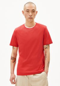 Rode t-shirt met korte mouwen van lichtgewicht katoen. Klassieke ronde hals, subtiele textuur en een eenvoudig ontwerp.