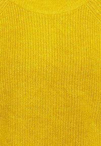 Suéter amarillo de punto con una superficie texturizada y escote redondo, que presenta un patrón acanalado y acogedor en toda su extensión.
