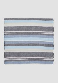 Couverture tissée avec des rayures bleues, grises et blanches alternées. Texture douce avec des bords effilochés. Forme rectangulaire, design léger.