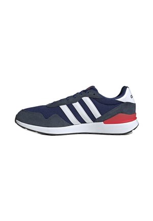 Navy blue athletic shoes with white stripes, mesh and suede materials, a thick white sole, and red accents on the heel.