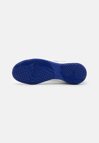 Suela de zapato con un exterior de goma azul, superficie texturizada, que presenta un patrón de espiga y un logotipo en relieve para mejorar el agarre.