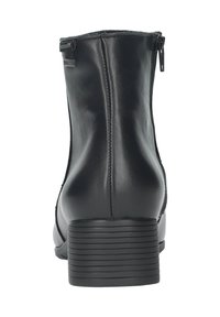 Botte chelsea en cuir noir avec une fermeture éclair sur le côté, bout rond et petit talon empilé. Texture lisse avec des détails de couture subtils.