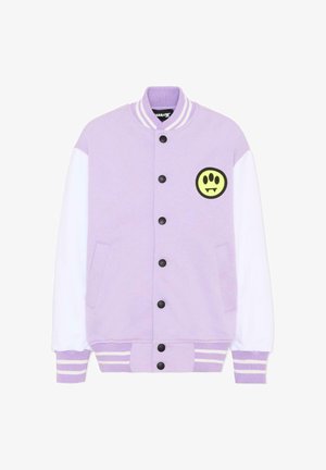 Chaqueta varsity color lavanda con mangas blancas, cuello y puños acanalados a rayas, botones de presión negros y una cara sonriente amarilla con colmillos en el pecho.