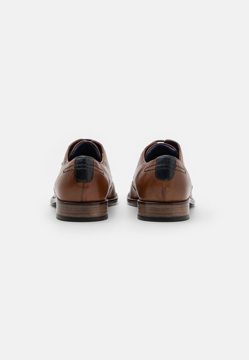 Zapatos de cuero marrón con un acabado suave, punta redonda y detalles en negro en el tacón. Equipados con un tacón bajo apilado.