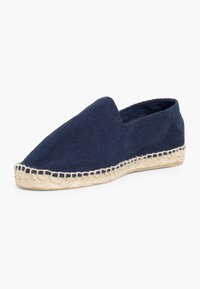 Marineblå espadrille slip-on sko med vævet tekstiloverdel og jute reb sål. Har en spids tå og minimalistisk design.
