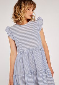 Blau-weißer gestreifter Kleid mit kurzen Rüschensäumen, Rundhalsausschnitt und gestuftem Design, aus leichtem Stoff gefertigt.