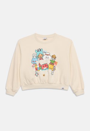 Sweat-shirt court crème avec des personnages de dessin animé colorés, dont une fille aux oreilles de lapin, des animaux et des objets, centrés sur le devant.