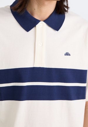Kortærmet polo t-shirt med krave i hvid med navy krave og to horisontale navy striber over brystet, båret af en person.