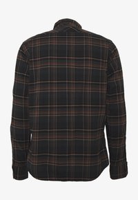 Camisa de cuadros negra con rayas naranjas y marrones, con mangas largas, un cuello clásico y un dobladillo recto. Tejido de textura suave.