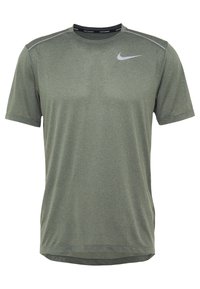 Zelené sportovní tričko s krátkým rukávem, texturovanou tkaninou, kulatým výstřihem a reflexními akcenty; obsahuje malé logo na hrudi.