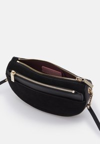 Borsa a tracolla nera in pelle e camoscio con due scomparti con zip, dettagli in acciaio dorato e una fodera interna liscia.