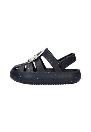 Sandale bleu marine taille enfant avec des taches blanches, orteils ouverts et bride arrière, ornée d'une décoration visage de panda sur la bride supérieure.