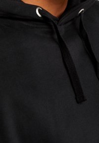 Schwarzer Hoodie aus einem strukturierten, weichen Stoff; verfügt über eine frontale Kängurutasche, eine Kapuze mit Zugband und silbernen Ösen sowie flachen schwarzen Zugbändern.