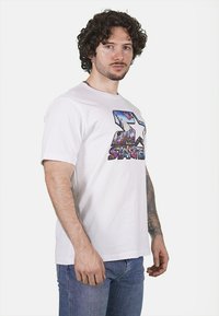 T-shirt bianca in cotone caratterizzata da un vivace design grafico con una grande stella e una scena urbana. Maniche corte e vestibilità standard.