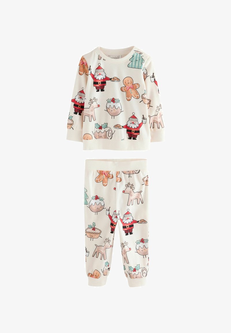 Ensemble de pyjama pour enfants en deux pièces en tissu doux de couleur crème. Comprend des imprimés festifs de Santa, de biscuits en pain d'épice et de rennes.