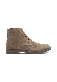 Stivaletti alla caviglia in suede beige con dettagli brogue, punta arrotondata e lacci beige. Presentano una superficie texturizzata e una suola piatta in gomma.