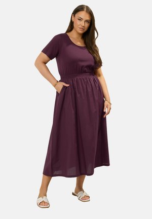 Vestido púrpura de manga corta y corte ajustado en el torso, con una cintura elástica, que cuenta con una falda fluida y bolsillos laterales, confeccionado en una tela ligera.