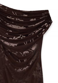 Draperad brun tygklänning med ett blommönster. Texturen är slät, med en lätt glans som framhäver designen och konturerna.