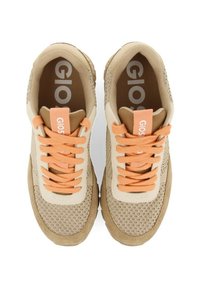 Baskets beiges avec texture en maille, accents crème et lacets orange. Présentent un logo bien visible et un col rembourré pour le confort.
