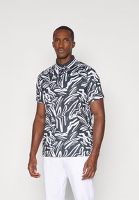 Polo de manga curta com um padrão abstrato de ondas em preto e branco, feito de um tecido suave e com gola.