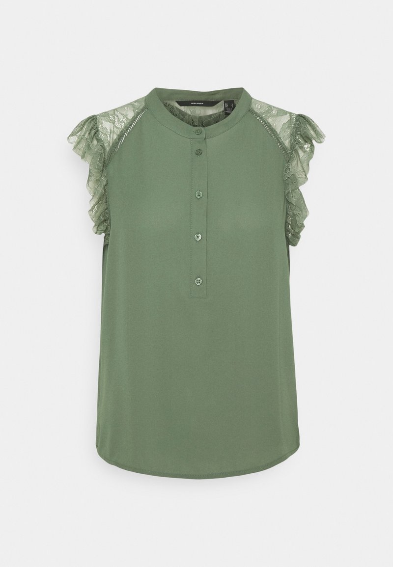 Blouse verte sans manches avec des détails en dentelle volantée sur les épaules, un col rond, et une patte de boutonnage frontale avec quatre boutons.