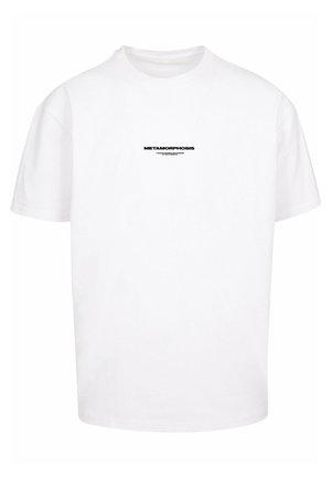 Fehér pamut póló rövid ujjakkal, kerek nyakkal, a elején fekete szöveggel, amelyen az "METAMORPHOSIS" felirat áll. Klasszikus szabás, minimalista dizájn.