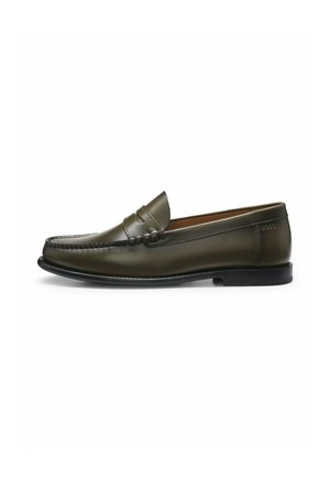Donkergroene leren herensloffer met mocassin-stiksels, penny-banddetail en zwarte zool op witte achtergrond.