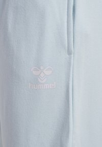 Jasnoniebieska bluza z miękkiego materiału, z białym haftowanym logo w kształcie pszczółki oraz napisem "hummel."