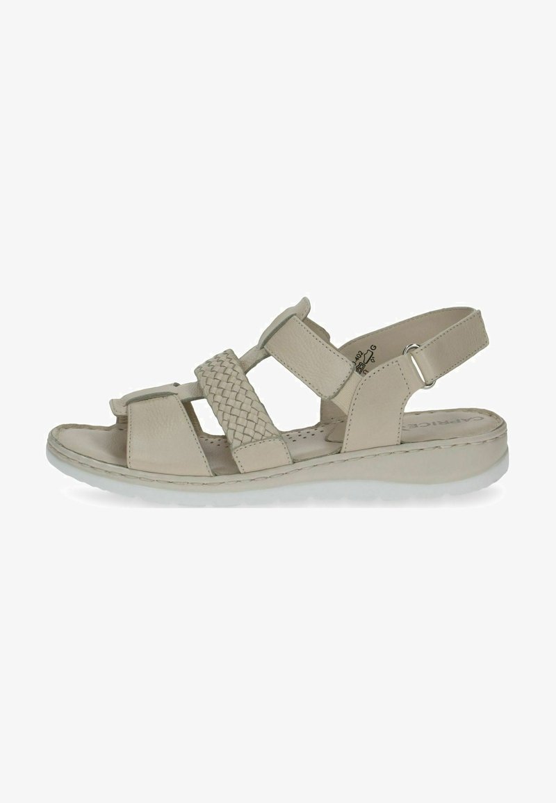 Beige sandal with woven straps, open toe design, adjustable back strap, flat sole, and textured footbed for comfort.