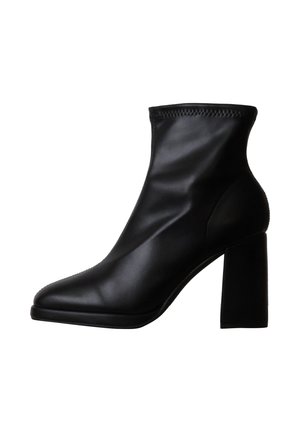 Bottine en cuir noir avec bout pointu et talon épais bloc, dessus lisse et bordure cousue au bord supérieur.